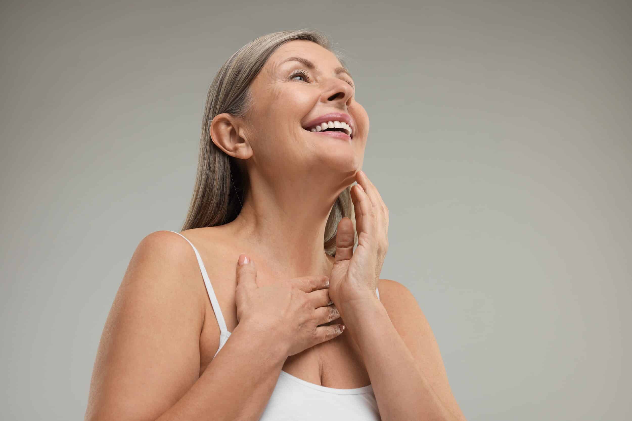 Mature woman smiling with firm, rejuvenated skin after Thermage treatment