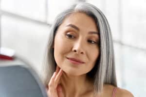 Mature woman looking in mirror at Dysport results
