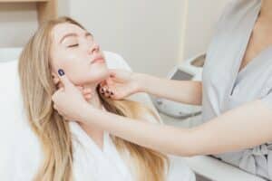 Aesthetic specialist examining woman's smooth skin after microdermabrasion treatment