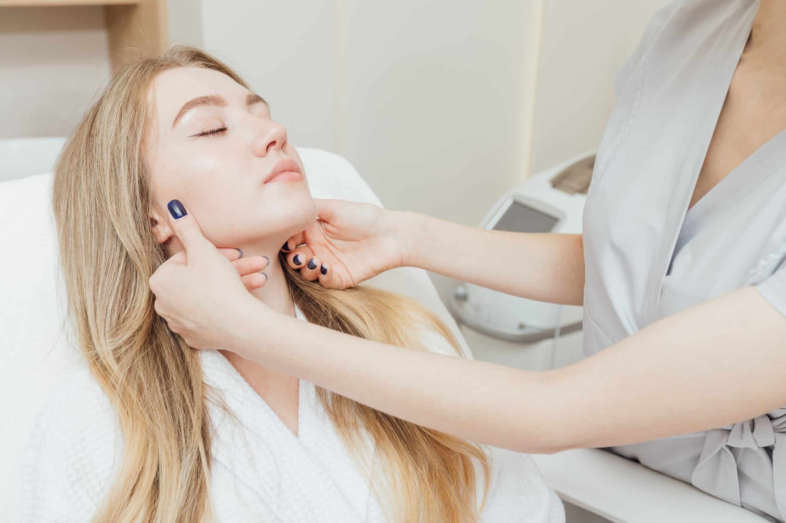 Aesthetic specialist examining woman's smooth skin after microdermabrasion treatment