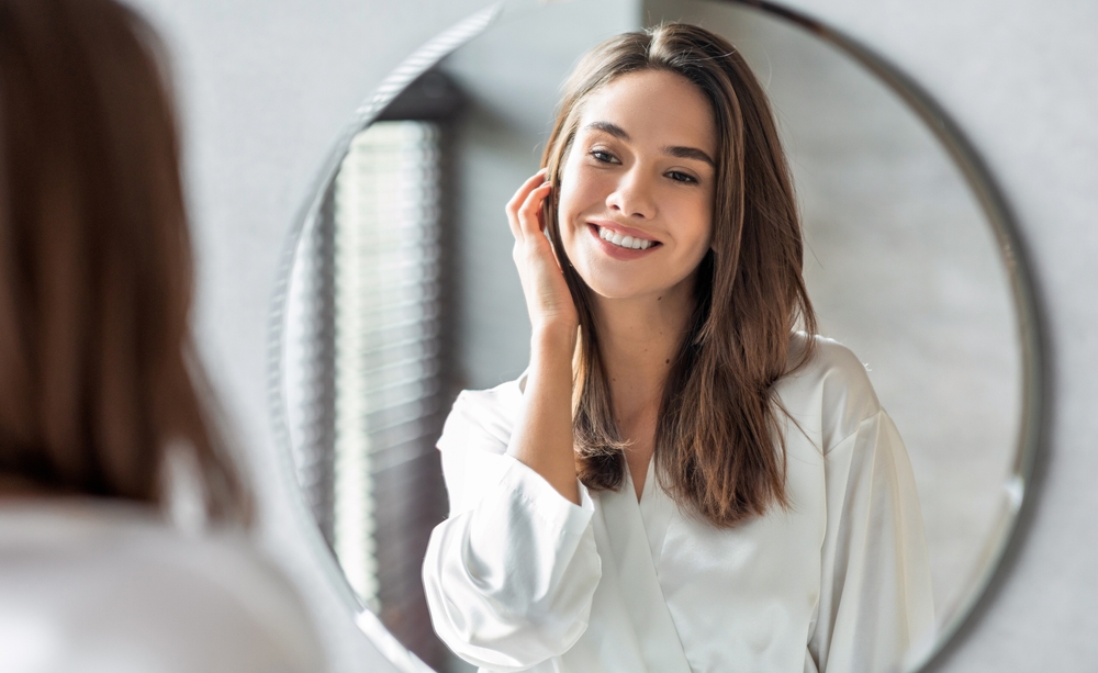 Woman smiling at her reflection after a SilkPeel Dermalinfusion treatment Woman smiling at her reflection after a SilkPeel Dermalinfusion treatment